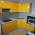 Желтый угловой кухонный гарнитур с белой столешницей