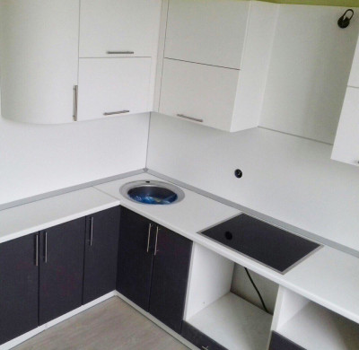 Бело-черная угловая кухня с глянцевыми радиусными фасадами