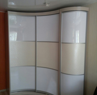 Белый радиусный шкаф в спальню с вставками из экокожи