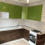 Коричневая угловая кухня с зелёным навесными шкафами