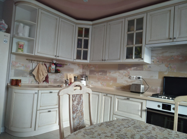 Угловая дубовая светло-бежевая кухня с радиусными фасадами
