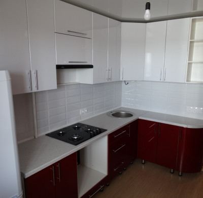Угловая кухня с радиусным фасадом и белыми навесными шкафами