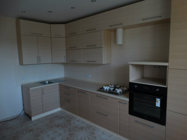 Светлый угловой кухонный гарнитур с фасадами цвета ясень