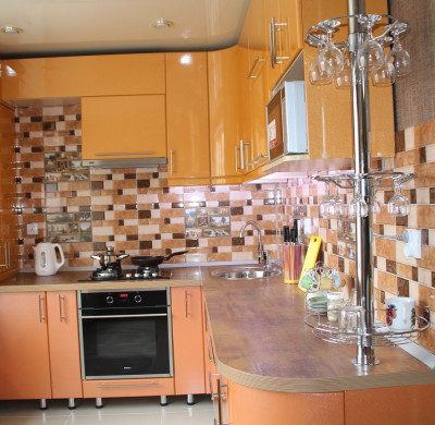 Двухцветный оранжевый кухонный гарнитур с радиусными фасадами