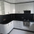 Белая угловая кухня с радиусным фасадом и черной столешницей