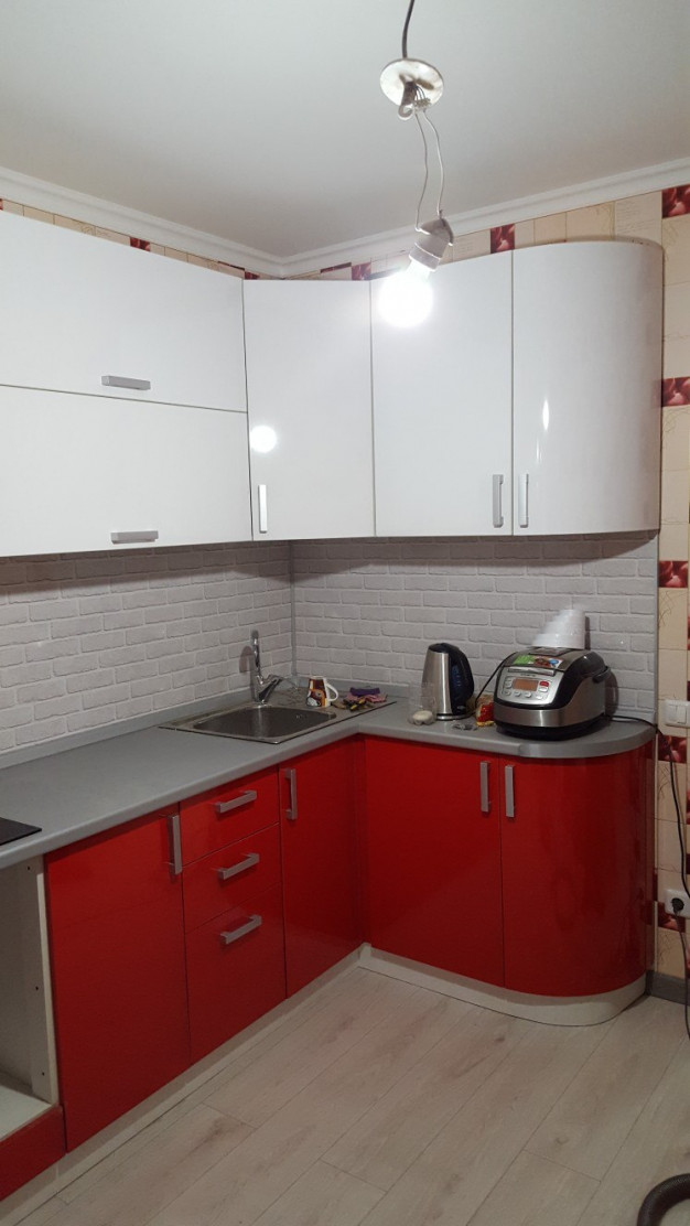 Красно-белая угловая кухня с радиусными фасадами