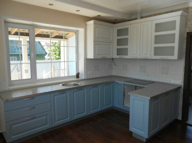 Голубая п-образная кухня с белым верхом и фигурными дверями