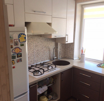 Угловая кухня с двухцветными коричнево-белыми фасадами