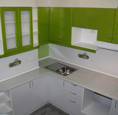 Белая угловая кухня с зелеными навесными шкафами