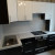 Черная угловая кухня с белыми навесными шкафами