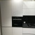 Современная белая угловая кухня с темно-серой столешницей