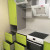 Зелёная угловая кухня с белыми навесными шкафами и пеналом