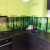 Коричневая угловая радиусная кухня с зелеными навесными шкафами