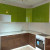 Коричневая угловая кухня с зелёным навесными шкафами