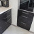 Чёрный прямой кухонный гарнитур с белыми навесными шкафами