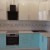 Двухцветная бирюзовая угловая кухня с белыми навесными шкафами