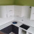 Бело-черная угловая кухня с глянцевыми радиусными фасадами