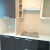 Угловая коричневая кухня с бежевыми навесными шкафами