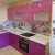 Розовая угловая кухня с белой столешницей