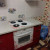 Красный прямой кухонный гарнитур с белыми навесными шкафами